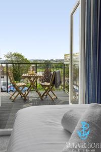 a bedroom with a balcony with a table and chairs at Stella Marina in Paignton