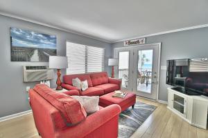 - un salon avec un canapé rouge et une télévision dans l'établissement Sea Esta at SunVillas E2, à Myrtle Beach