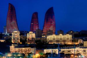 a city skyline with tall buildings at night at Nord West Hotel in Baku