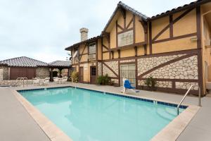 a swimming pool in front of a house at Triplodge of Santa Clarita in Santa Clarita