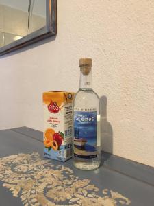 una botella de alcohol y una bolsa de naranjas en una mesa en Fotini's Beach, en Olympiakí Aktí