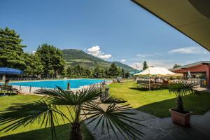 un resort con piscina e palme di Sankt Johann Spa Suites & Apartments a Prato allo Stelvio