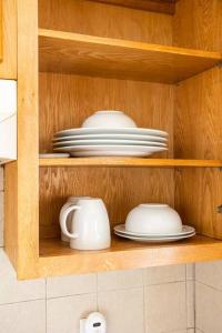 a wooden cabinet with plates and bowls and dishes at Daphy Ruby Floor 2 in Newark