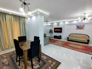 - un salon avec une table, des chaises et un canapé dans l'établissement Cozy Modern Apartment In El-Nozha, au Caire