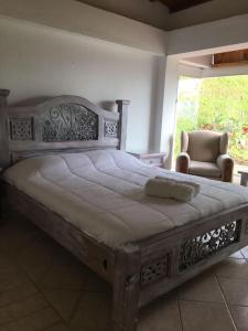a bedroom with a large wooden bed and a chair at La Casa de la Montaña in La Vega