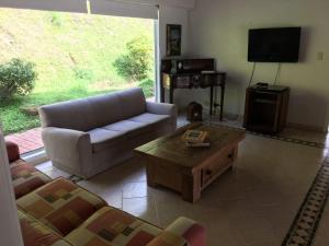 a living room with a couch and a coffee table at La Casa de la Montaña in La Vega