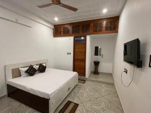 a bedroom with a bed and a flat screen tv at Govind Atithi Grah in Ayodhya