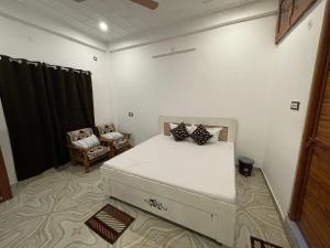1 dormitorio con 1 cama y 1 silla en Govind Atithi Grah en Ayodhya