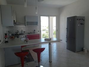 a kitchen with a refrigerator and red stools in it at Villa Gelsemium in Siracusa