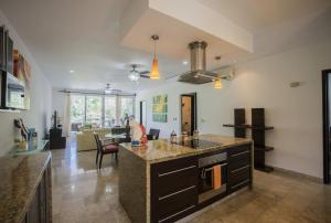 a kitchen with a counter and a living room at Playa Village Condo by BVR in Playa del Carmen