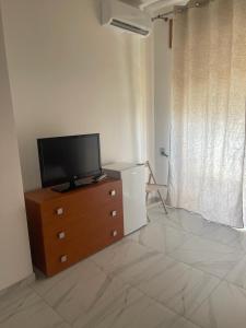 a living room with a television on a dresser at Camere Lorenzo in Porto Cesareo +26 photos