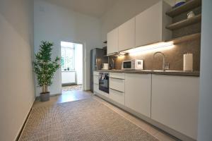 une cuisine avec des armoires blanches et une plante en pot dans l'établissement Trendy Apartment 3 Zimmer zentral gelegen, à Vienne