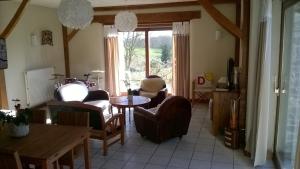 a living room with chairs and a table and a window at La P'tit' Fugue in La Bouexière