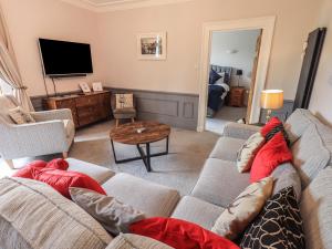 Una sala de estar con un sofá y un televisor. en Red Screes, en Ambleside