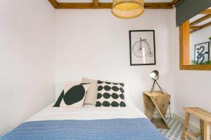 una camera da letto con un letto con cuscini bianchi e neri di Estudio NovoCentro CongressosLX Factory a Lisbona