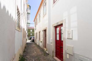 an alley with red doors in an alley between two buildings at Estudio NovoCentro CongressosLX Factory in Lisbon
