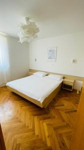 a bed in a room with a wooden floor at Apartaments Bee in Vinjerac