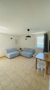 un soggiorno con divani blu e un tavolo di Apartaments Bee a Vinjerac (Castel Venier)