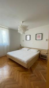 a bedroom with a large bed and a chandelier at Apartaments Bee in Vinjerac