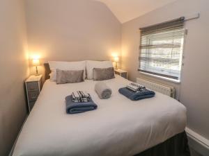 a bedroom with a large white bed with towels on it at Wayland House in Bakewell