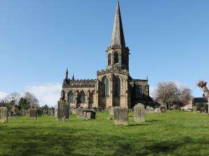 an old church with a tall steeple in a cemetery at Wayland House in Bakewell