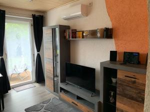 ein Wohnzimmer mit einem Flachbild-TV auf einem Entertainment-Center in der Unterkunft FEWO Anja in Vellmar