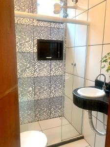 a bathroom with a shower with a sink and a mirror at CASA DE PRAIA COM PISCINA EM ILHÉUS-BA a 50m DA PRAIA in Ilhéus +16 photos