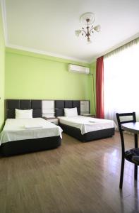 two beds in a room with green walls at Apartments 37B in Batumi