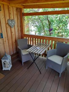 - une terrasse couverte en bois avec 2 chaises et une table dans l'établissement Ferienhaus Helmig, à Gohrisch