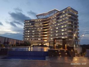 un gran edificio con una piscina frente a él en The Nove Apartment Junior Penthouse - Studio Type en Nongsa