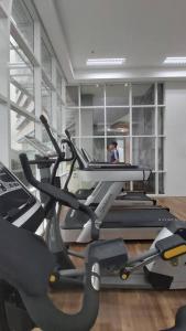 un gimnasio con equipo cardiovascular con una persona de fondo en The Nove Apartment Junior Penthouse - Studio Type en Nongsa