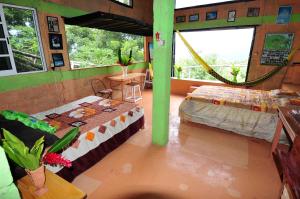 Zimmer mit 2 Betten und einer Hängematte. in der Unterkunft Ecobiosfera in Catemaco