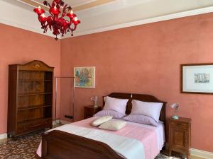 a bedroom with a large bed and a chandelier at Residenza Porta Brescia in Peschiera del Garda