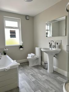 a white bathroom with a sink and a toilet at Kim Family Holiday Get-Away 4 Bedrooms 2 Baths in Blackpool