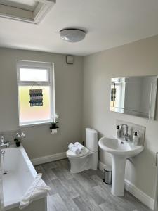 a white bathroom with a sink and a toilet at Kim Family Holiday Get-Away 4 Bedrooms 2 Baths in Blackpool