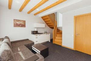 a living room with a couch and a staircase at Villa Vanilla in Sigulda