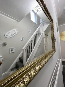 ブラックプールにあるKim Family Holiday Get-Away 4 Bedrooms 2 Bathsの階段付きの廊下の壁面鏡