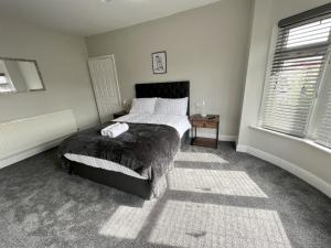 a bedroom with a bed and two windows at Kim Family Holiday Get-Away 4 Bedrooms 2 Baths in Blackpool