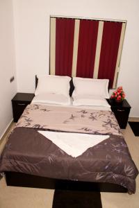 Bett in einem Zimmer mit zwei Kissen in der Unterkunft Sunny Daze in Cherai Beach