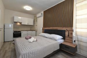 a bedroom with a large bed and a kitchen at SOFIA'S Studio & Room in Zadar