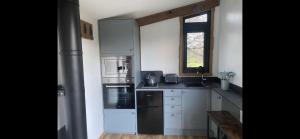 una cocina con electrodomésticos blancos y una ventana en Impeccable shepherds hut sleeping up to 4 guests, en Minehead