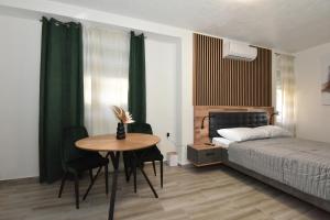 a bedroom with a table and a bed and a bed and a table and chairs at SOFIA'S Studio & Room in Zadar
