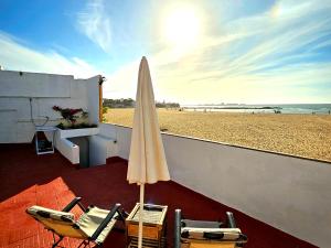 een strand met 2 stoelen en een parasol bij Charmante Maison vue sur mer à Mohammédia plage Manesmane ! in Mohammedia