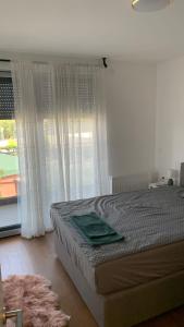 een slaapkamer met een bed en een groot raam bij Penthause StAnto, novogradnja, blizina Maksimira in Zagreb