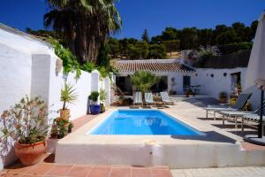 a swimming pool in a patio with chairs and a house at Almohalla51 in Archidona