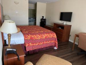 Habitación de hotel con cama y TV de pantalla plana. en Riviera Inn and Suites, en Riviera