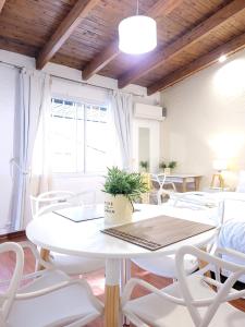 a dining room with a table and white chairs at "Casa Amalia Apartamentos" Ubicación Privilegiada con Jardín in Mendoza