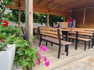 a patio with benches and a table and some flowers at Ergys Apartments in Ksamil