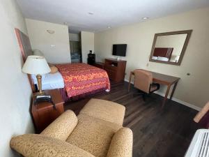 a hotel room with a bed and a couch and a table at Riviera Inn and Suites in Riviera