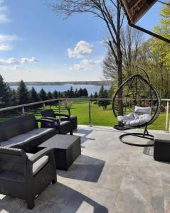 a patio with a bench and a swing at THE VIEW - WILLA z basenem in Iława